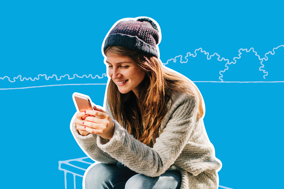 young woman sitting on a bench with a smartphone, wearing a toque